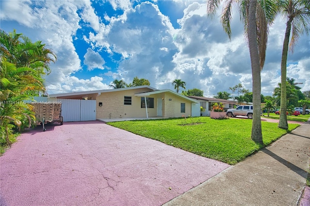 ranch-style home featuring a carport and a front lawn