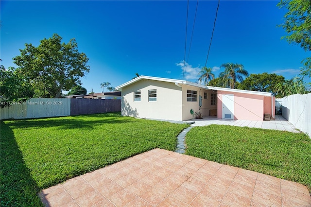 rear view of property with a lawn and a patio area