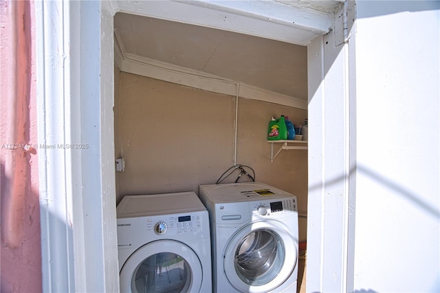 clothes washing area with washing machine and dryer and ornamental molding