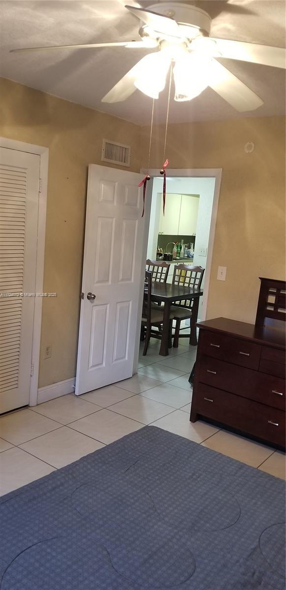 unfurnished bedroom featuring ceiling fan and light tile patterned flooring