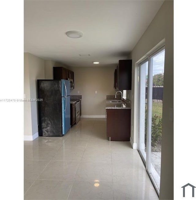 kitchen featuring sink, light tile patterned floors, and stainless steel appliances