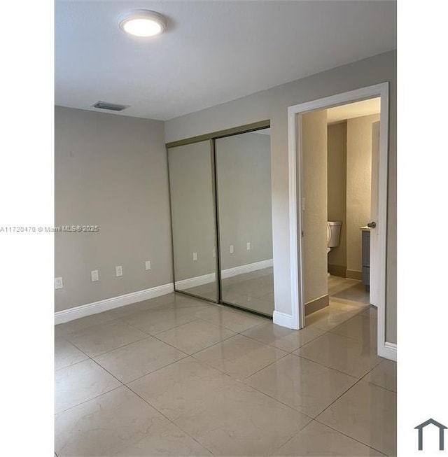 unfurnished bedroom featuring light tile patterned flooring and a closet