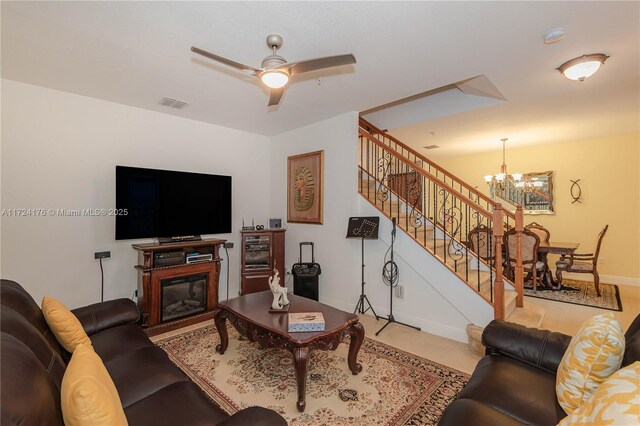 living room featuring ceiling fan with notable chandelier and light tile patterned flooring