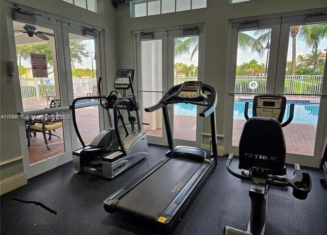 exercise room with ceiling fan and french doors