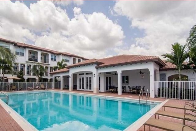 view of pool with ceiling fan, a patio, and french doors