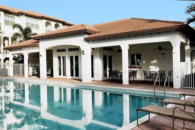 rear view of house featuring an outbuilding, a community pool, ceiling fan, french doors, and a patio area