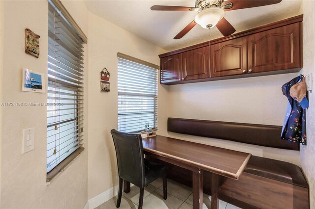 office space with ceiling fan, light tile patterned flooring, and baseboards