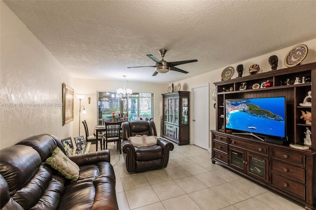 living room featuring ceiling fan with notable chandelier, a textured ceiling, and light tile patterned flooring