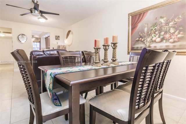 tiled dining space featuring baseboards and ceiling fan
