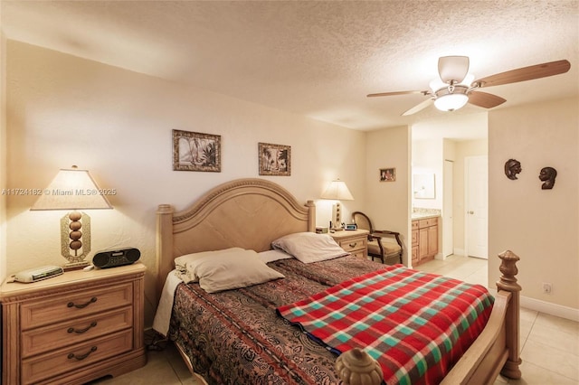 bedroom featuring a textured ceiling, ensuite bath, a ceiling fan, light tile patterned flooring, and baseboards