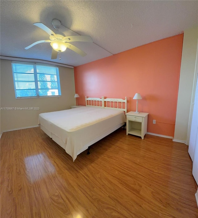 unfurnished bedroom with ceiling fan, wood-type flooring, and a textured ceiling