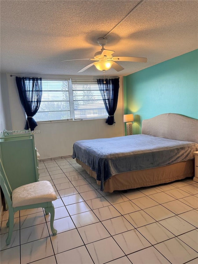 tiled bedroom with ceiling fan and a textured ceiling