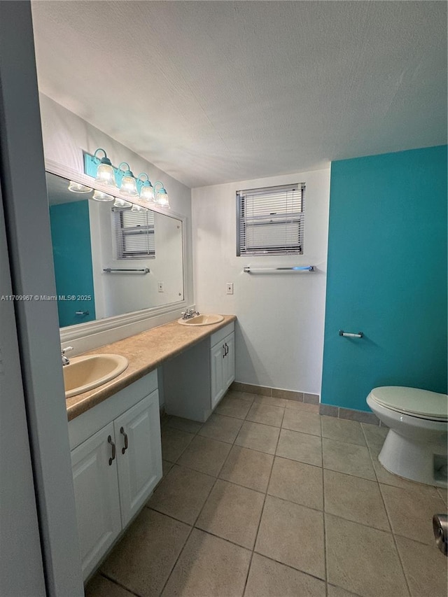 bathroom featuring tile patterned flooring, a textured ceiling, vanity, and toilet