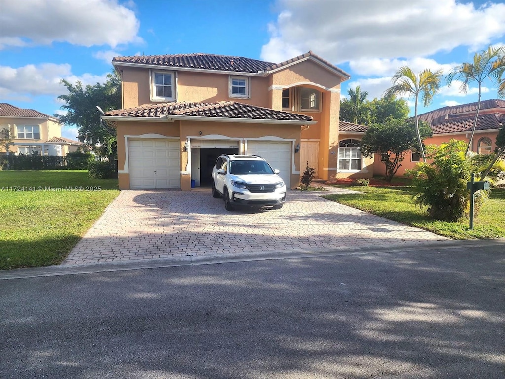 mediterranean / spanish house with a front lawn and a garage