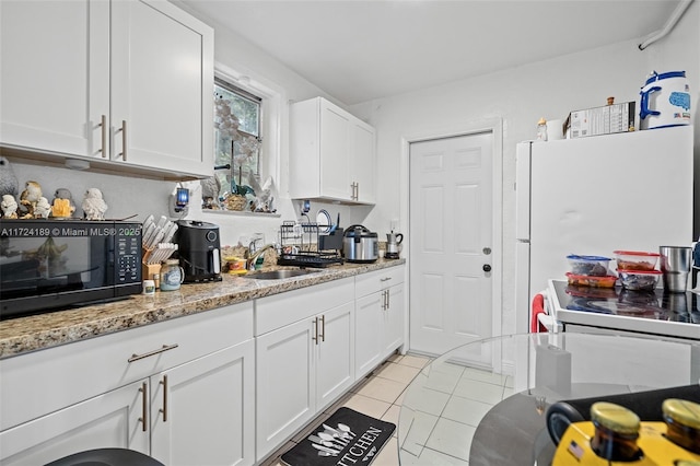 kitchen featuring sink, white cabinetry, light tile patterned floors, and light stone counters