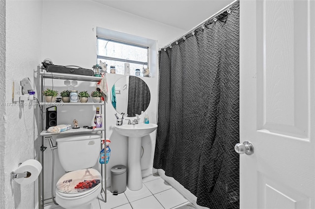 bathroom featuring toilet, tile patterned flooring, and sink