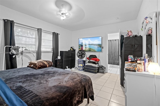 bedroom with ensuite bathroom, ceiling fan, and light tile patterned floors