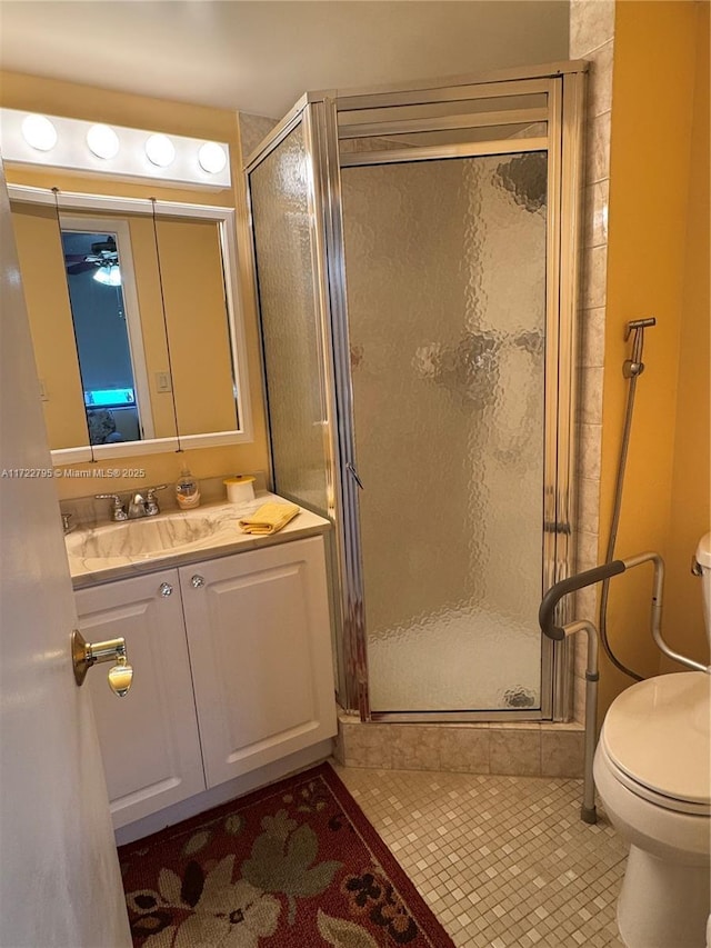 bathroom featuring toilet, an enclosed shower, vanity, and tile patterned floors