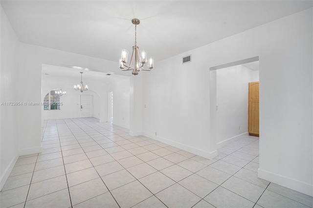 spare room with light tile patterned floors and a notable chandelier