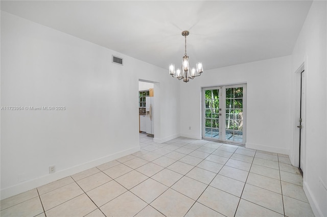 unfurnished room with light tile patterned floors, a chandelier, and french doors