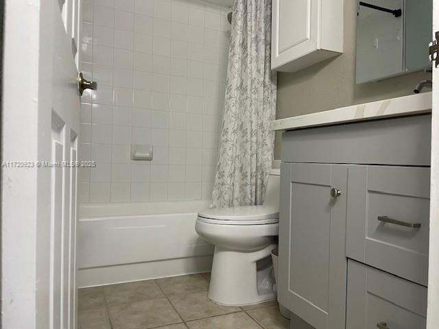 full bathroom with tile patterned floors, shower / bath combo, toilet, and vanity