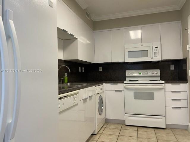 kitchen with white cabinetry, light tile patterned flooring, white appliances, and sink