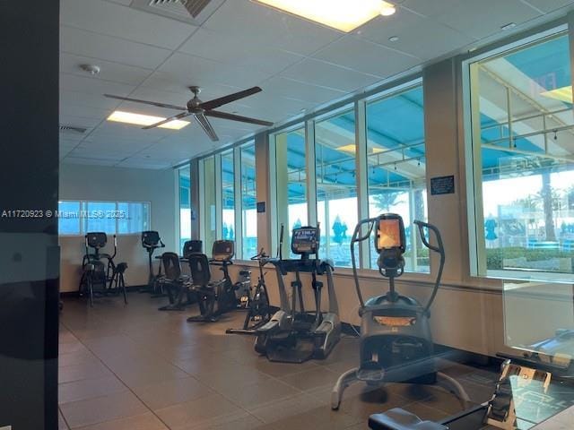 exercise room featuring a drop ceiling and ceiling fan