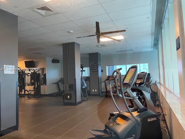 exercise room featuring a drop ceiling and ceiling fan