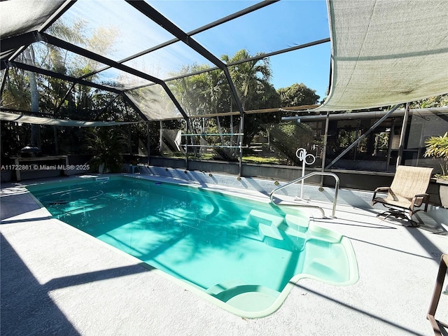 view of swimming pool featuring glass enclosure and a patio area