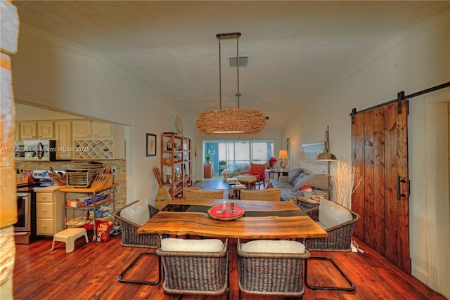 dining space with vaulted ceiling, a barn door, and wood-type flooring