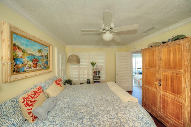 bedroom with a textured ceiling, ceiling fan, and ornamental molding