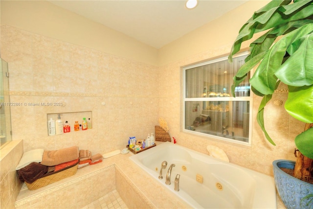 bathroom with tile walls and tiled tub