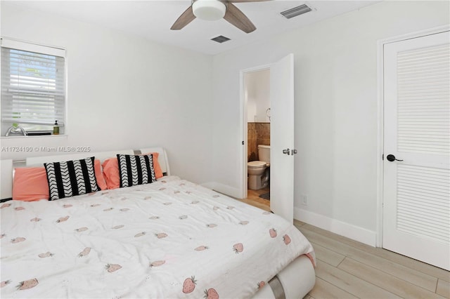 bedroom featuring connected bathroom, hardwood / wood-style floors, and ceiling fan