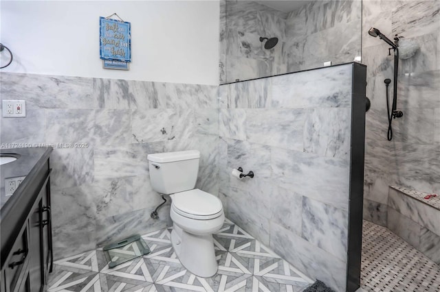 bathroom featuring vanity, a tile shower, tile walls, and toilet