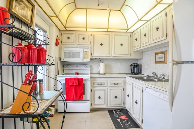 kitchen with white appliances, backsplash, white cabinets, sink, and light tile patterned floors