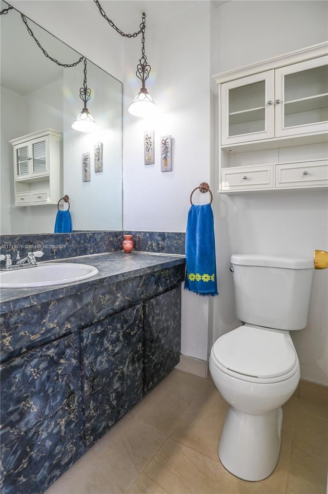 bathroom with tile patterned flooring, vanity, and toilet