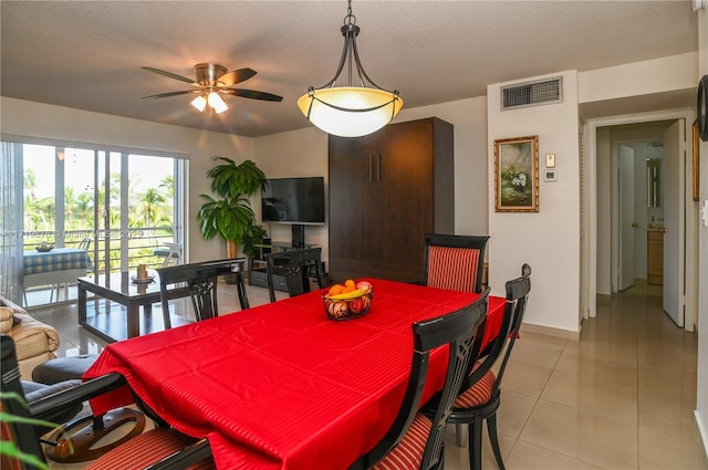 tiled dining space featuring ceiling fan and a textured ceiling