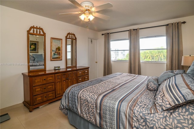 tiled bedroom featuring a textured ceiling and ceiling fan