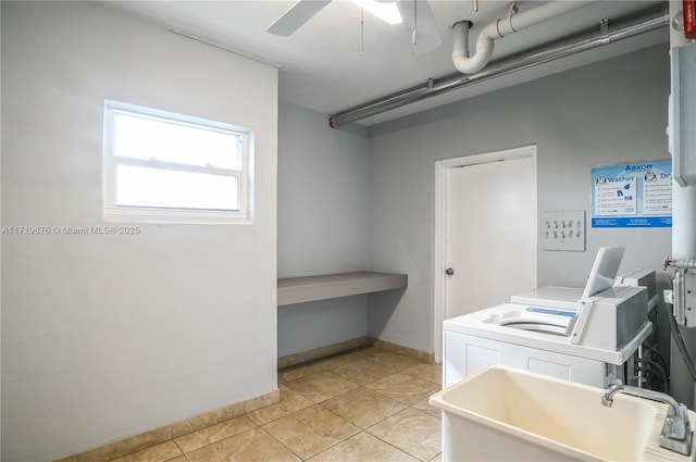 clothes washing area featuring light tile patterned flooring, ceiling fan, washer and dryer, and sink