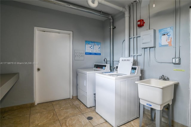 laundry room with sink, light tile patterned flooring, and independent washer and dryer