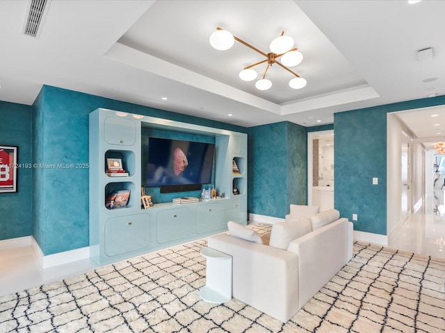 living room with a raised ceiling and a chandelier