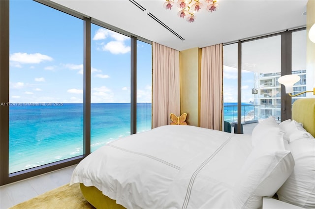 bedroom with a beach view, a wall of windows, and a water view