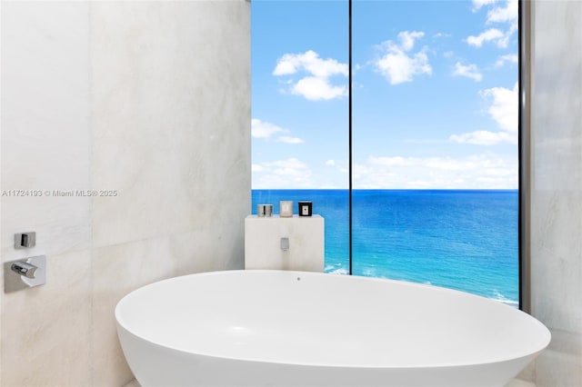 bathroom with a tub and a water view