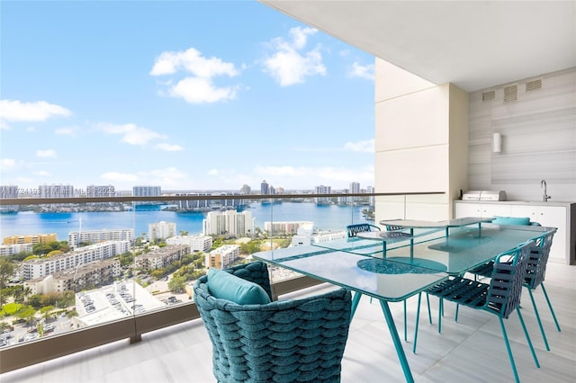 balcony with sink and a water view