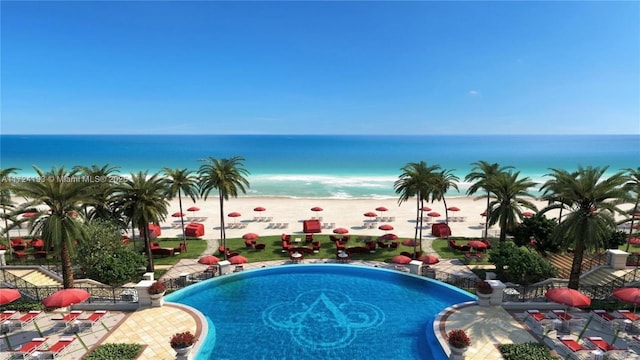 view of swimming pool featuring a view of the beach and a water view