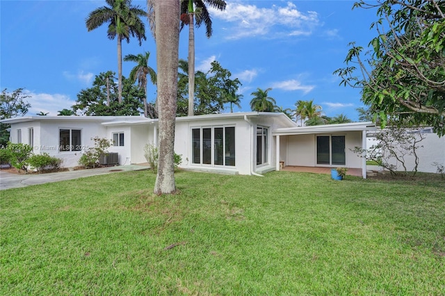 rear view of house featuring a lawn and cooling unit