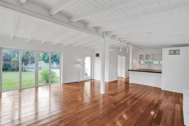 unfurnished living room featuring lofted ceiling with beams and hardwood / wood-style flooring