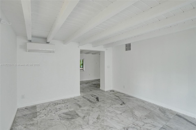 unfurnished room featuring a wall unit AC and beam ceiling