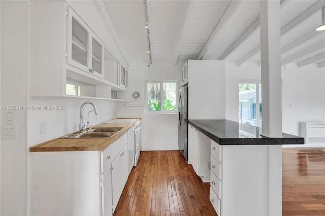 kitchen featuring sink, white cabinetry, kitchen peninsula, and track lighting