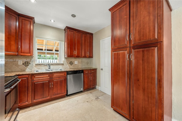 kitchen featuring light stone countertops, appliances with stainless steel finishes, backsplash, and sink